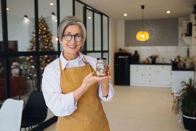 Senior woman holds glass jar with cereals in his hands