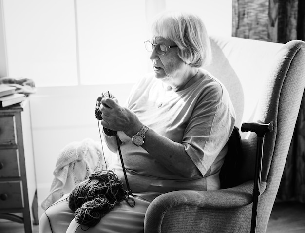 Free photo senior woman knitting at home