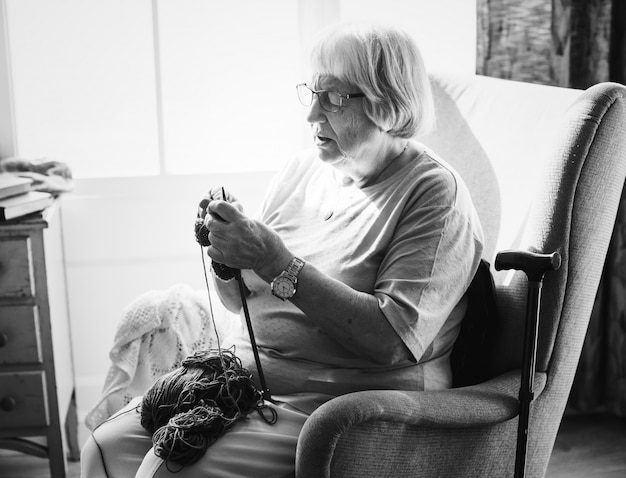 Senior woman knitting at home
