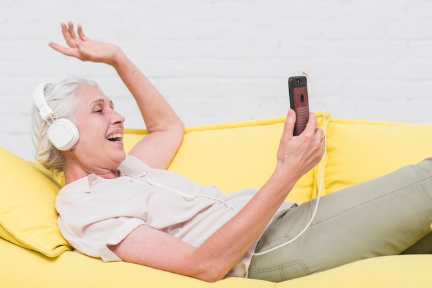 Senior woman listening music on headphone