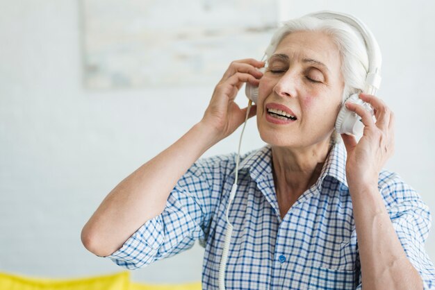 Senior woman listening music on headphone