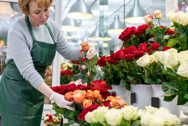 Старшая женщина, глядя после красивых цветов