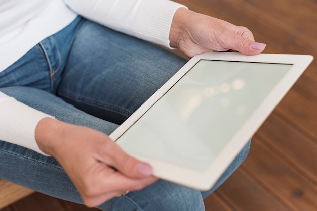 Free photo senior woman looking on her tablet indoors