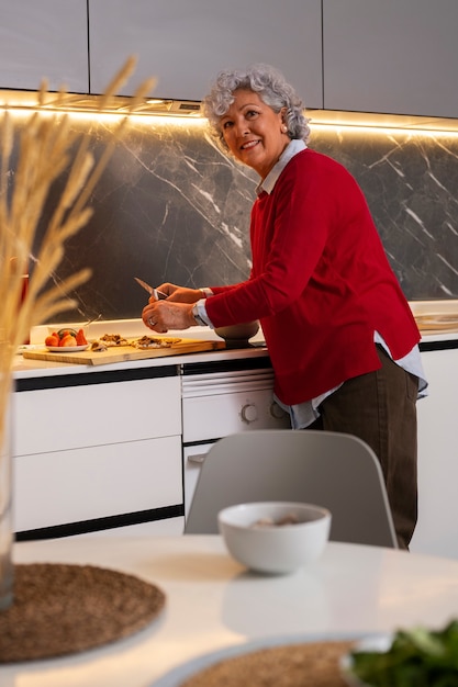 無料写真 自宅のキッチンでイチジクを使った料理を作る年配の女性