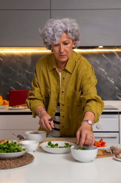 Senior woman making dish with figs in the kitchen