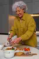 Free photo senior woman making dish with figs in the kitchen