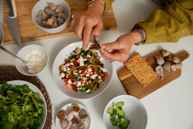 Foto gratuita senior donna che fa il piatto con i fichi in cucina