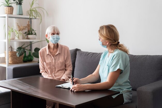 Senior woman in nursing home with nurse during check-up