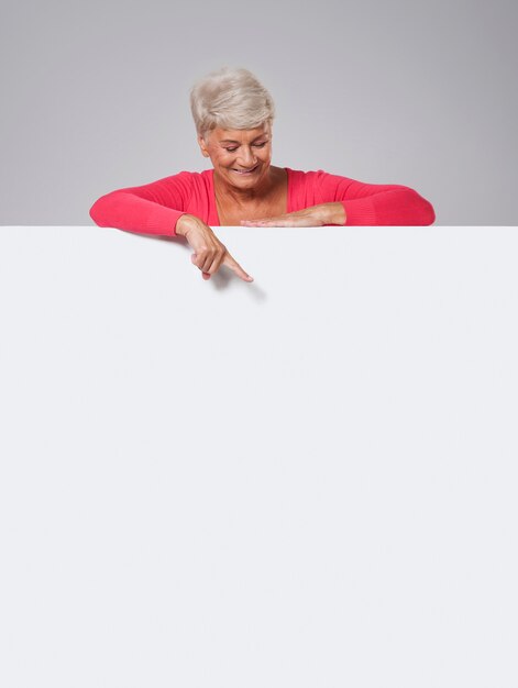 ホワイトボードを覗く年配の女性