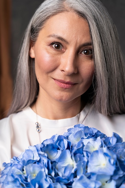 Free photo senior woman portrait with flowers bouquet