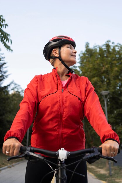 屋外で自転車に乗る年配の女性