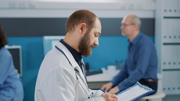 Senior woman signing checkup files to receive medical support and assistance with alternative medicine. old patient doing signature on papers after consultation with male physician