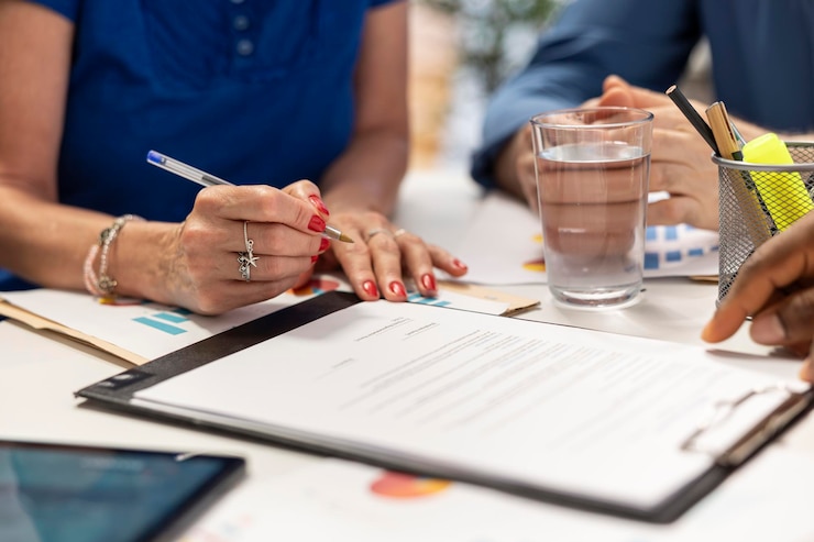 Free Photo senior woman signing the new retirement plan contract in a meeting