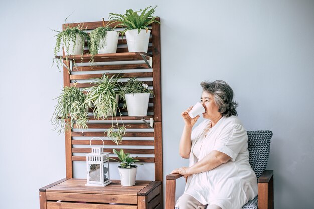 Senior woman sitting and drinking coffee or milk