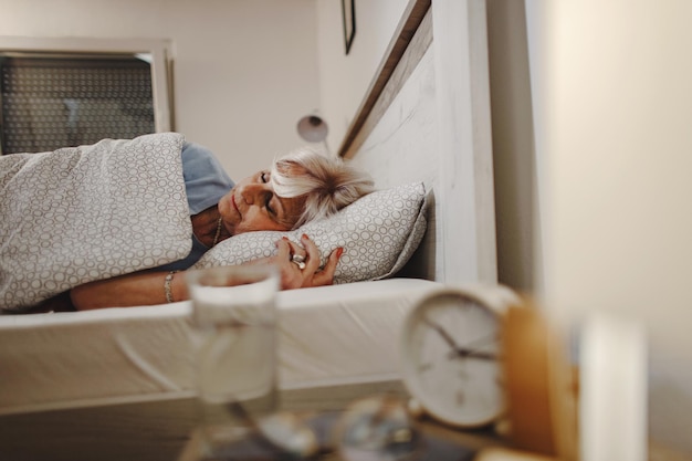 Бесплатное фото Пожилая женщина спит в постели ночью