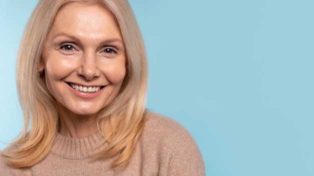 Senior woman smiling against a blue background