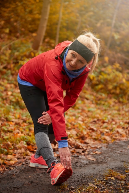 Free photo senior woman stretching in public park