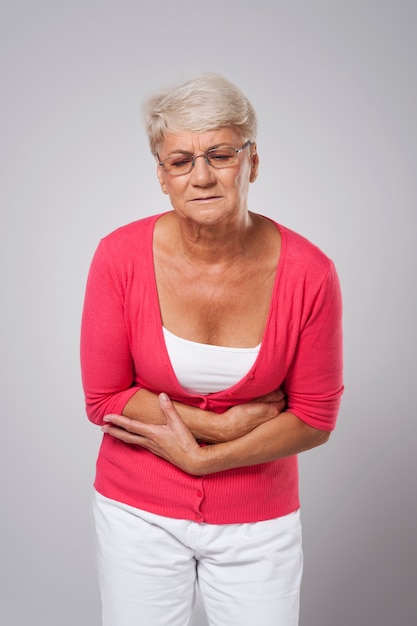 Free photo senior woman suffering from stomach ache