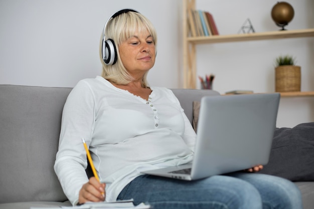 Senior woman taking an online class on her laptop at home