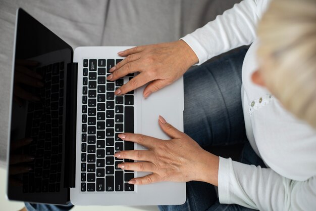 Senior woman taking an online class on her laptop at home