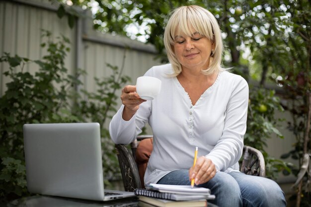 Senior woman taking an online class on her laptop at home