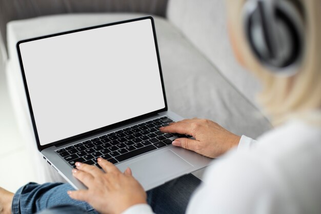 自宅でノートパソコンでオンラインクラスを受講している年配の女性