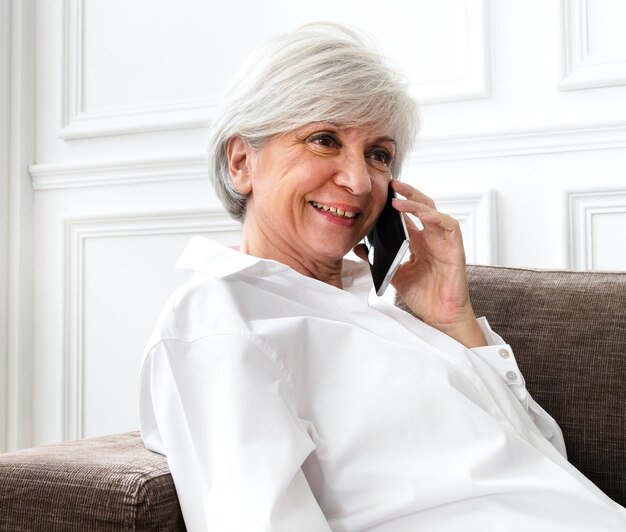 Free photo senior woman talking on the phone at home