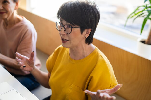 Senior woman talking with friends at a cafe