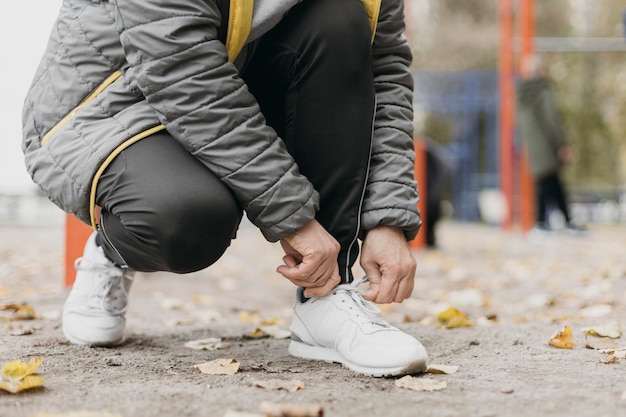 Foto gratuita senior donna che lega i lacci delle scarpe prima di lavorare all'aperto