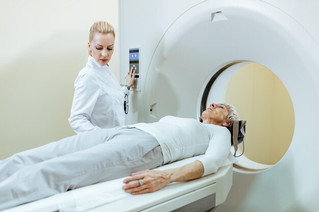의사가 절차를 감독하는 동안 MRI 스캐너를 받고 있는 고위 여성