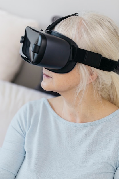 Free photo senior woman in vr goggles on couch