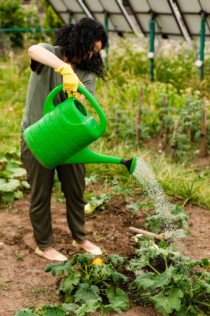 Free photo senior woman watering the crops