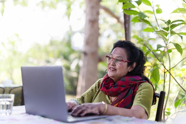 ノート​パソコン​で​作業している​眼鏡​を​かけている​年配​の​女性