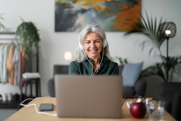 Senior woman wearing headphones medium shot