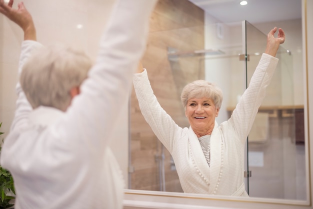 Senior woman with hands raised