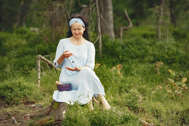 Senior woman with hindu things. Lady in a blue dress. Brunette sitting.