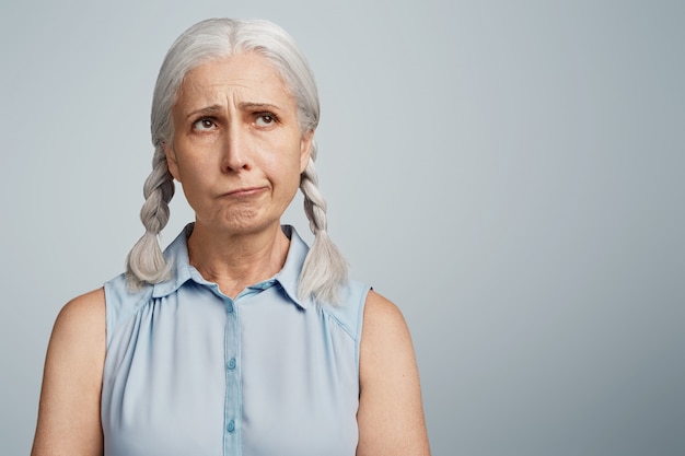 Senior woman with pigtails dressed in blue blouse