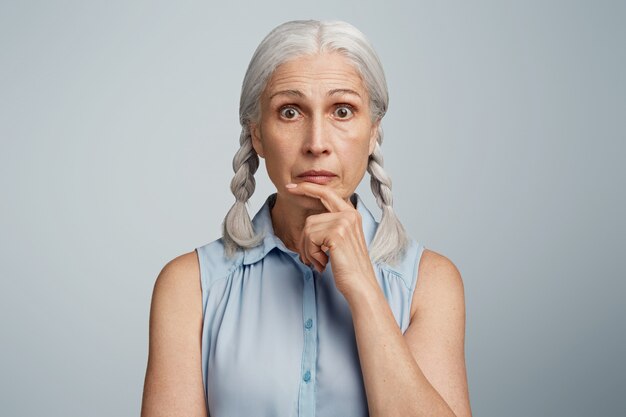 Senior woman with pigtails dressed in blue blouse