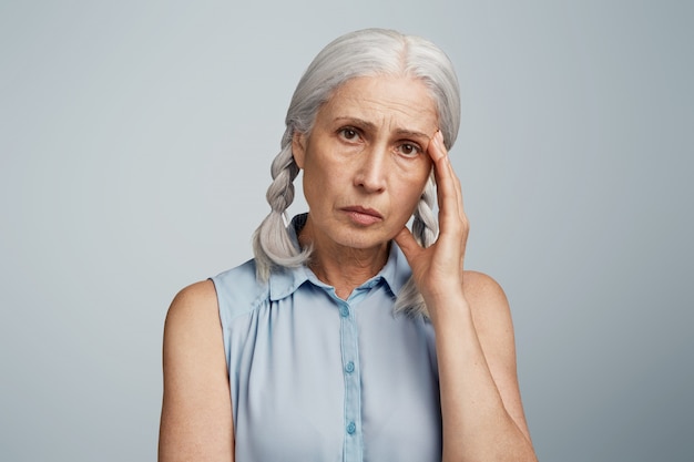 Senior woman with pigtails dressed in blue blouse