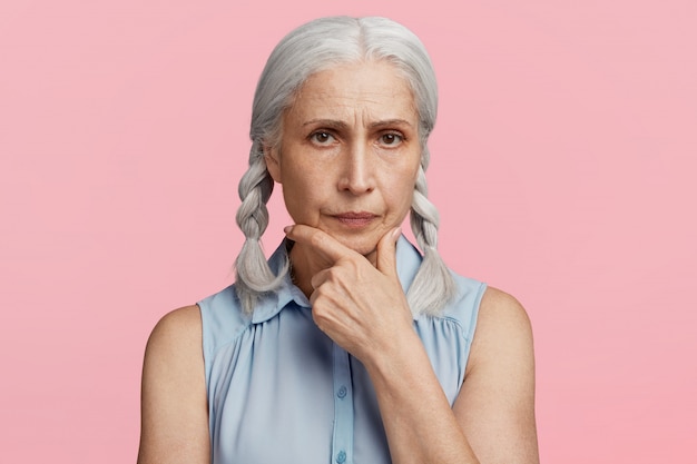 Senior woman with pigtails dressed in blue blouse