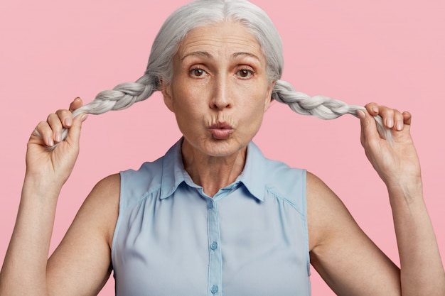 Free photo senior woman with pigtails dressed in blue blouse