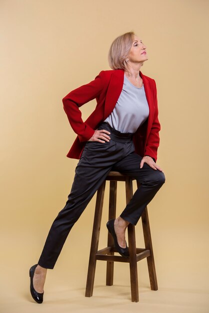 Senior woman with short hair posing on chair