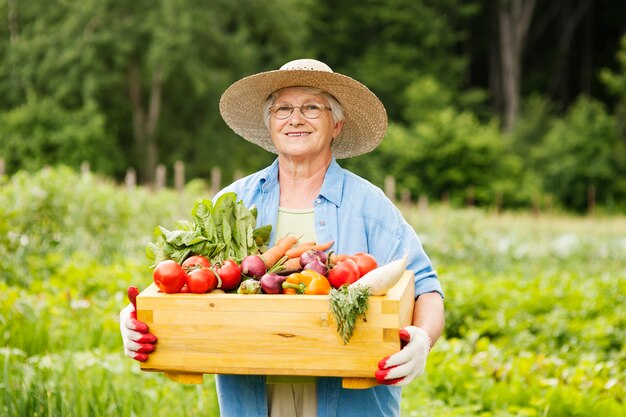 野菜を持つ年配の女性