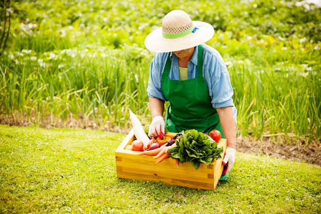 野菜を持つ年配の女性