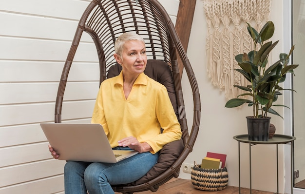 Foto gratuita donna senior che lavora al suo computer portatile