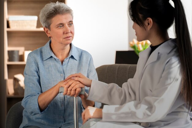 Senior woman and young nurse close up