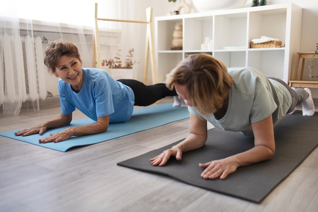 Senior women doing fitness together at home