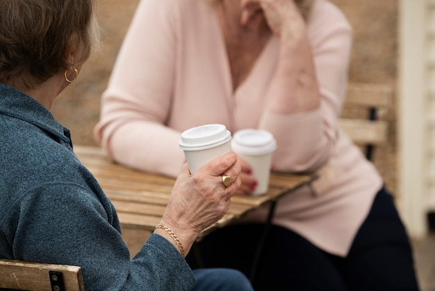 無料写真 テーブルにコーヒーカップを持つ年配の女性