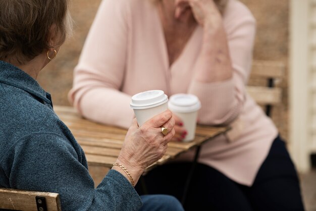 Donne anziane con tazze di caffè a tavola