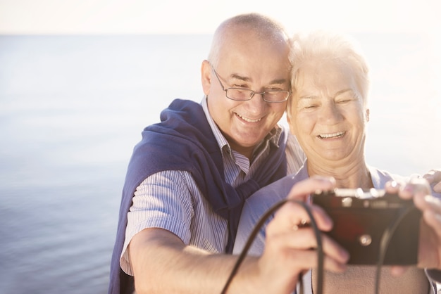 Free photo seniors taking selfie on the beach